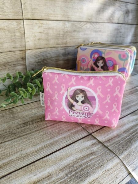 Porta-Moedas Básico Estampado em poliéster colecção "Outubro Rosa" Tamanho pequeno (11x15 cm) . Cores contrastantes.  Estampa em Poliéster. Forro interior de algodão. Fecho de correr. Os Porta-Moedas  básico da coleção especial "Outubro Rosa", criada para apoiar a conscientização sobre o cancro de mama. Este porta-moedas básico modelo tradicional de tamanho pequeno (11x15 cm) são perfeitas para guardar os seus itens essenciais do dia a dia. Características: Design Temático: 8 padrões diferentes com mensagens de coragem e prevenção. Materiais de Qualidade: Exterior em poliéster durável e interior em algodão macio. Versatilidade: Ideal para carregar carregadores de telemóvel, pen drives, fones, medicamentos, batons, chaves, dinheiro e outros pequenos utilitários. Feitas à Mão: Cada peça é artesanal e única. Estes Porta-moedas são totalmente feitas à mão, garantindo um acabamento impecável e um toque personalizado. Disponibilizamos uma unidade de cada padrão em stock. Para encomendas adicionais, o produto será fabricado por encomenda, assegurando a exclusividade e o cuidado artesanal.