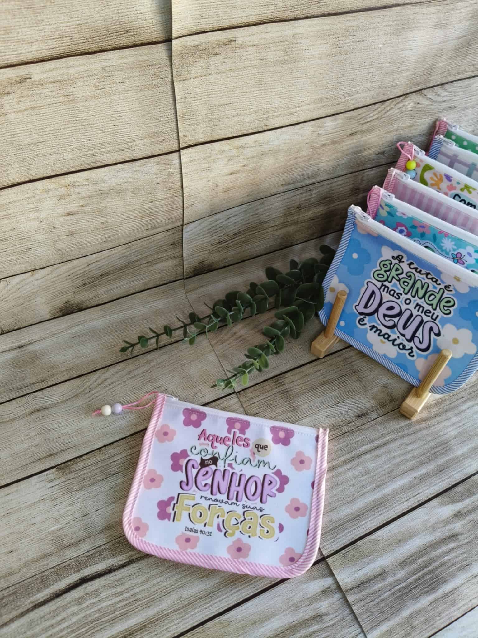 Bolsa multiusos de poliéster estampada com frases de fé e motivacionais. Tamanho pequeno. Cores contrastantes. Forro interior de algodão. Fecho de correr. Cada bolsa multiusos tem dimensões de 14x16 cm e apresenta uma frase de fé e motivadora única. Características: Design Exclusivo: 16 padrões diferentes, cada um com uma frase inspiradora de fé e motivação. Materiais de Qualidade: Exterior em poliéster resistente e interior em algodão macio. Tamanho Compacto: Ideal para guardar carregadores de telemóvel, pen drives, fones, medicamentos, batons, chaves, dinheiro e outros pequenos utilitários. Feitas à Mão: Cada bolsa é artesanal, garantindo um toque especial e único. Estas bolsas multiusos são totalmente feitas à mão, garantindo um acabamento impecável e um toque personalizado. Disponibilizamos uma unidade de cada padrão em stock. Para encomendas adicionais, o produto será fabricado por encomenda, assegurando a exclusividade e o cuidado artesanal.